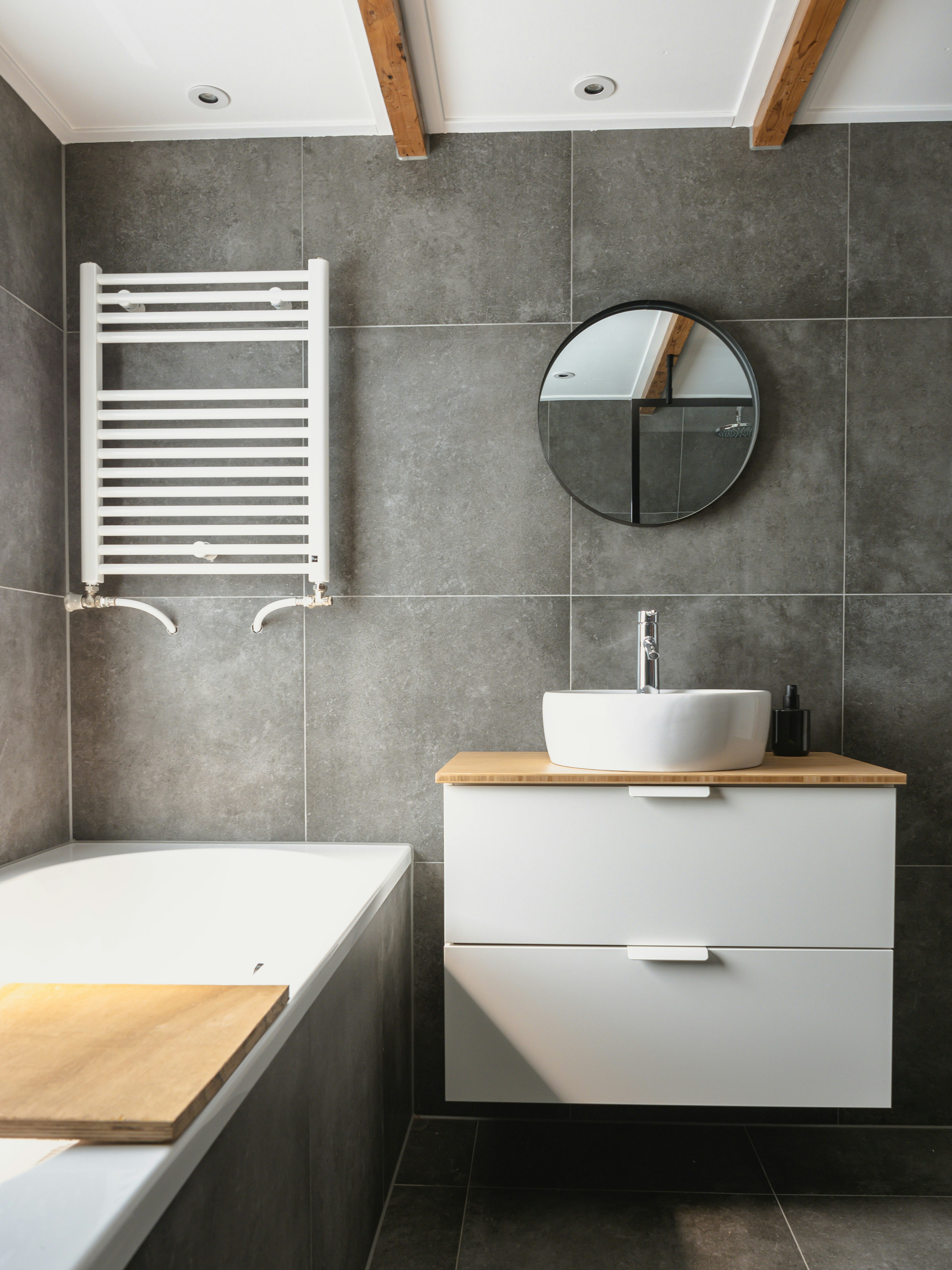 Clean modern bathroom with grey tiles and vessel sink
