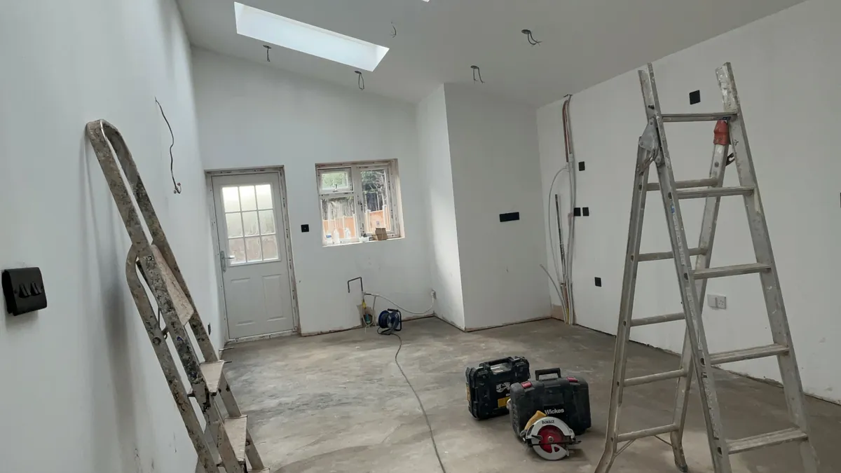 Extension interior during fit-out with skylights and a side door