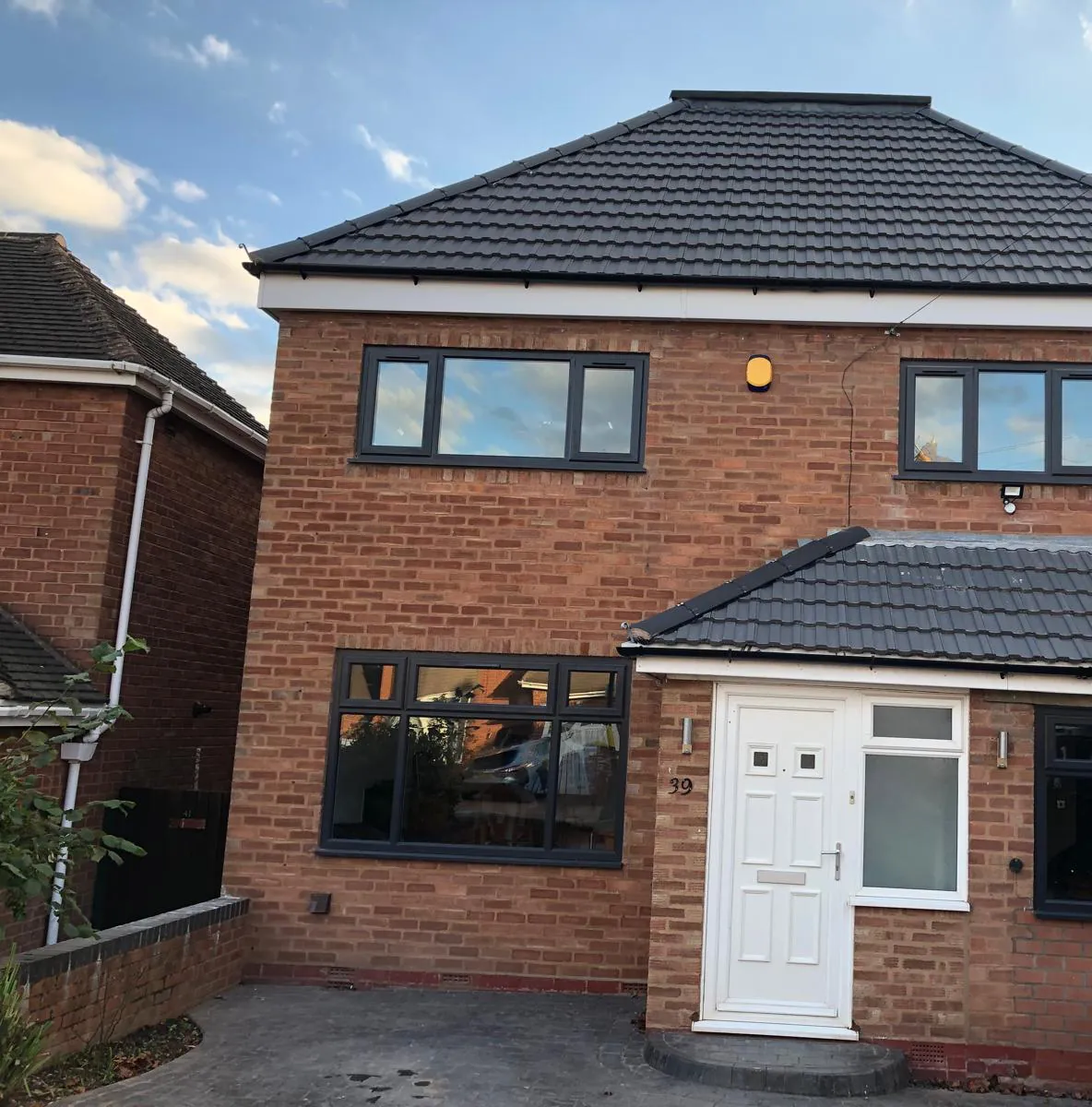 Completed house renovation with a new tiled roof, windows and porch