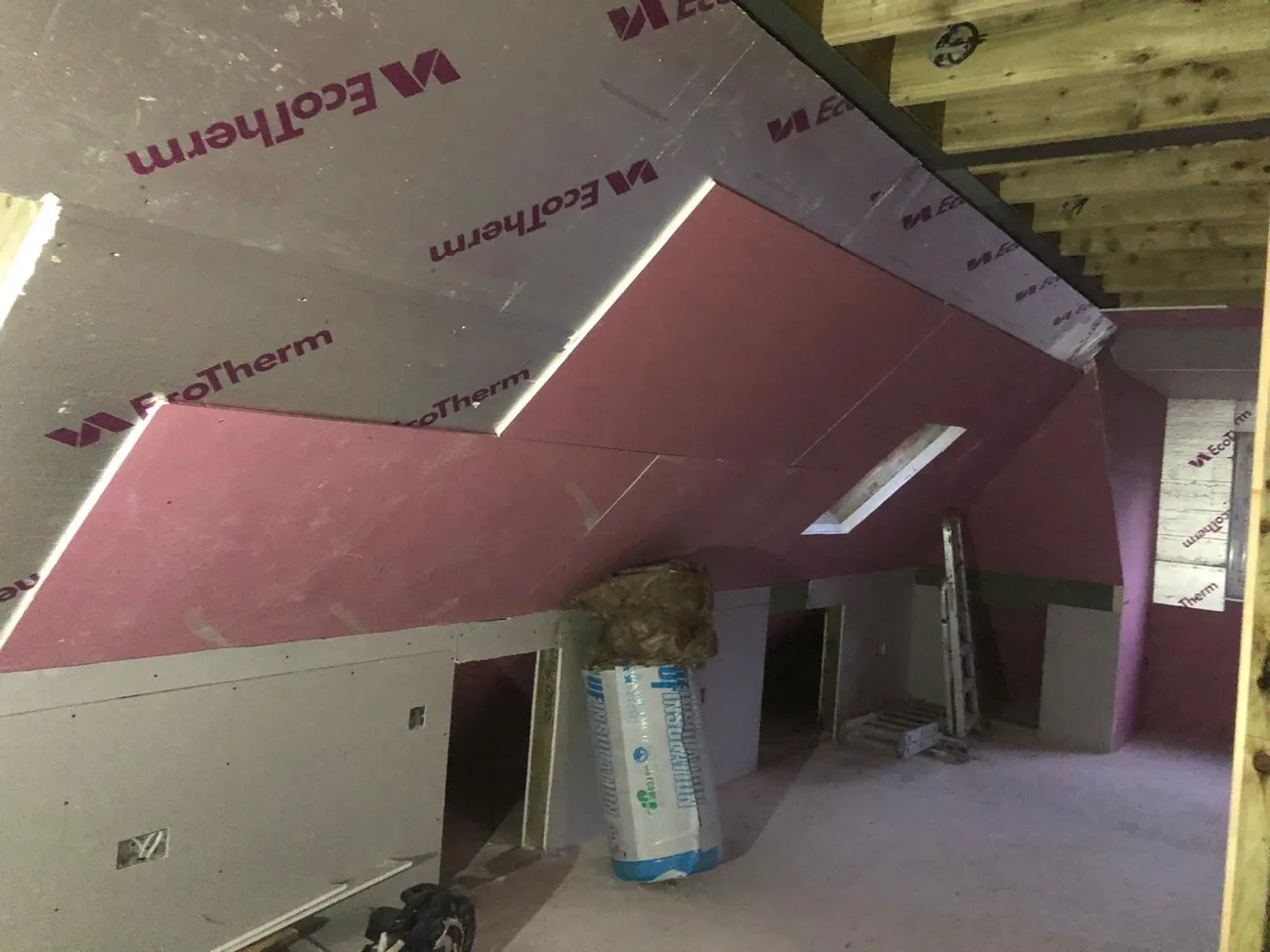 Insulation boards fitted to a loft slope during a conversion