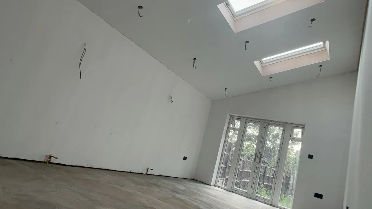 Open-plan extension interior with a vaulted ceiling and skylights