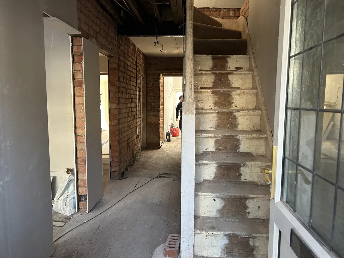 Hallway during a full house renovation with the staircase stripped back